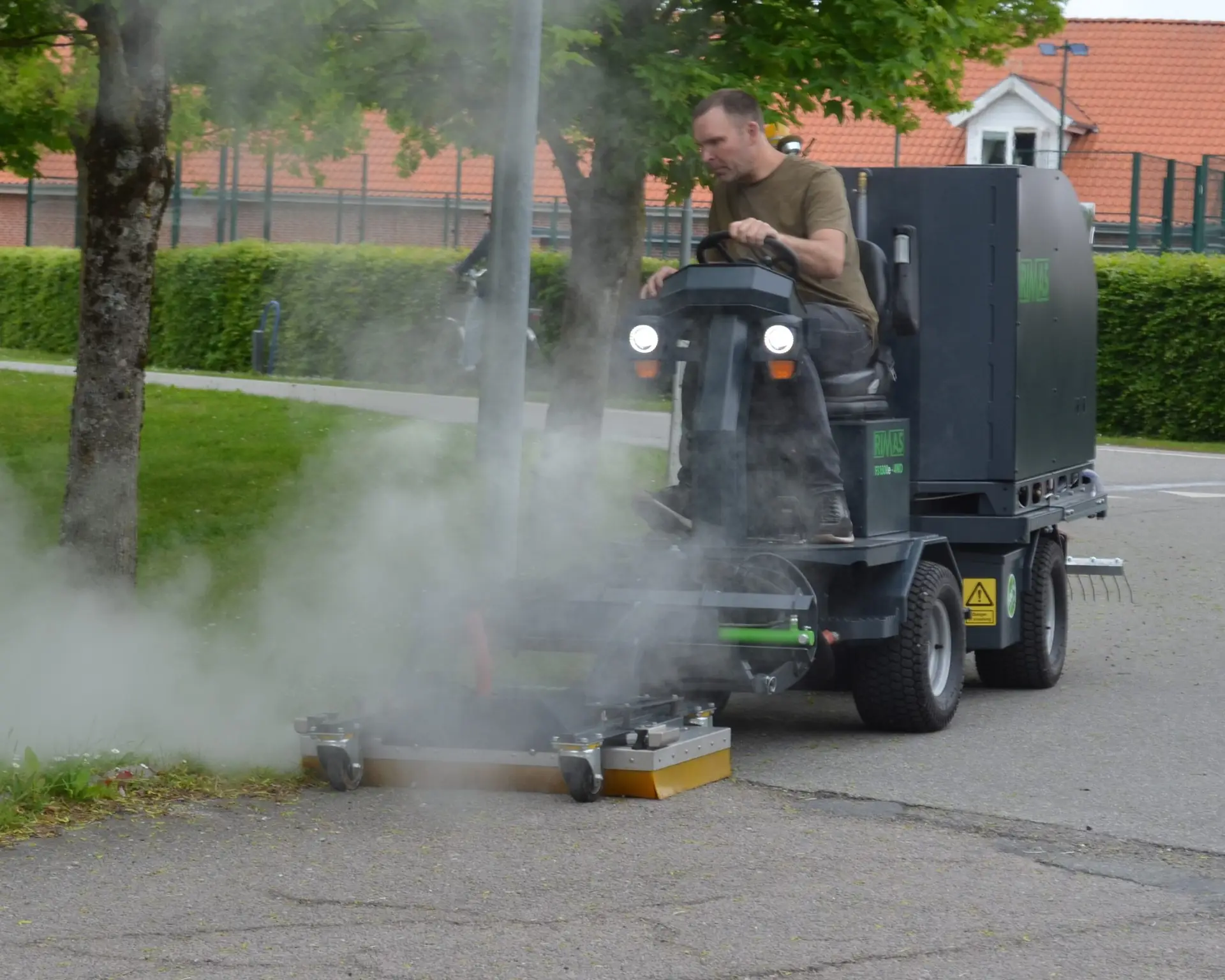 Mand fjerner ukrudt med Rimas varmtvandsanlæg monteret på Rimas FS 1500E redskabsbærer